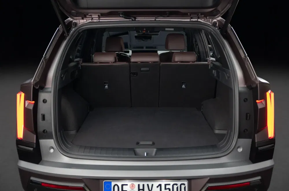 Coffre spacieux du Kia EV9 avec sièges rabattus, optimal pour le transport de bagages volumineux.