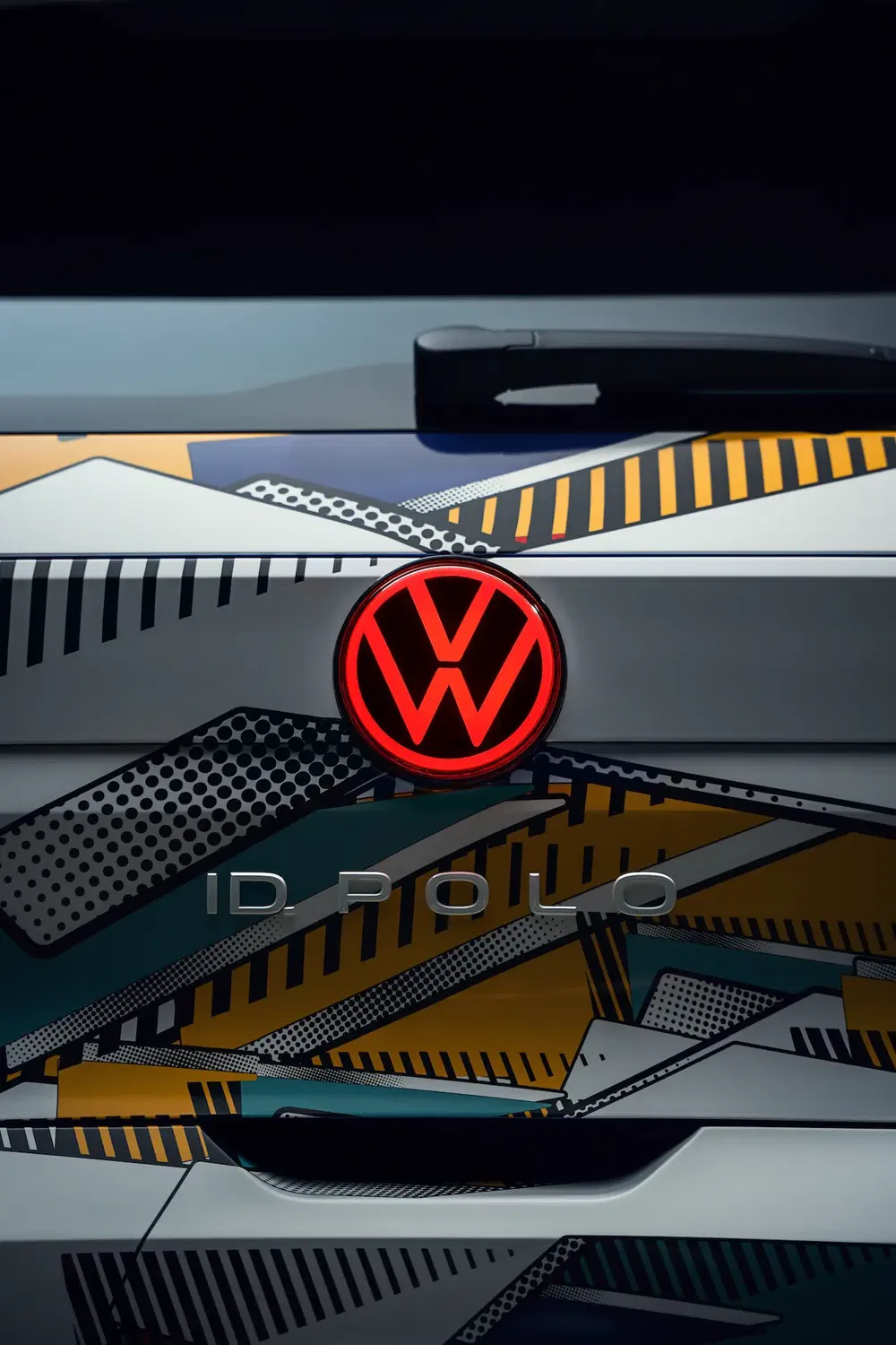 Arrière de la Volkswagen ID Polo avec motif coloré géométrique et logo rouge illuminé.