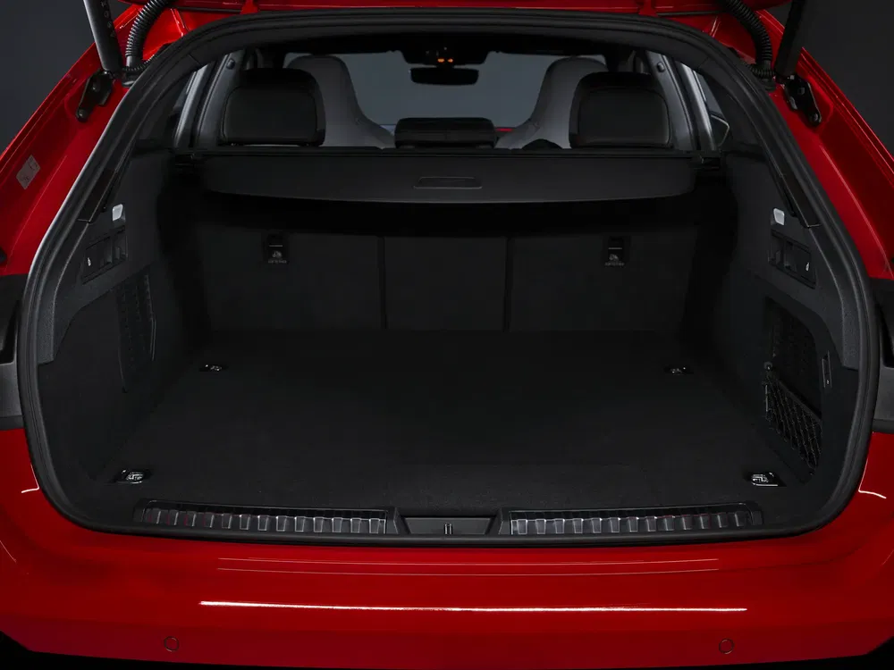 Ruime kofferbak van een rode Audi auto, neerklapbare achterbank, zwarte binnenafwerking.