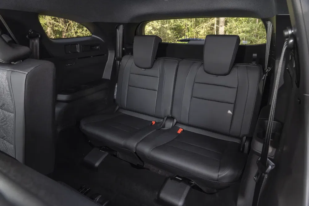 Intérieur de voiture avec sièges arrière en cuir noir, configuration SUV spacieuse.