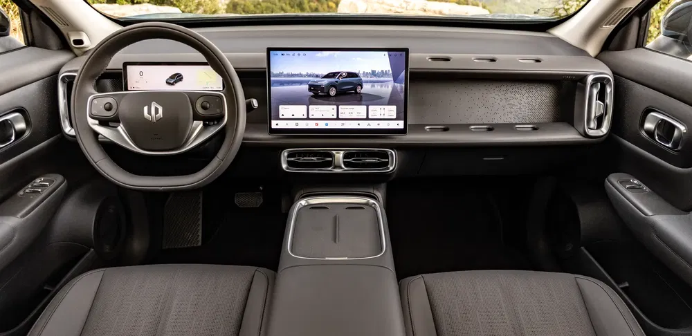 Moderne elektrische autointerieur met centraal touchscreen en minimalistisch stuurwiel.