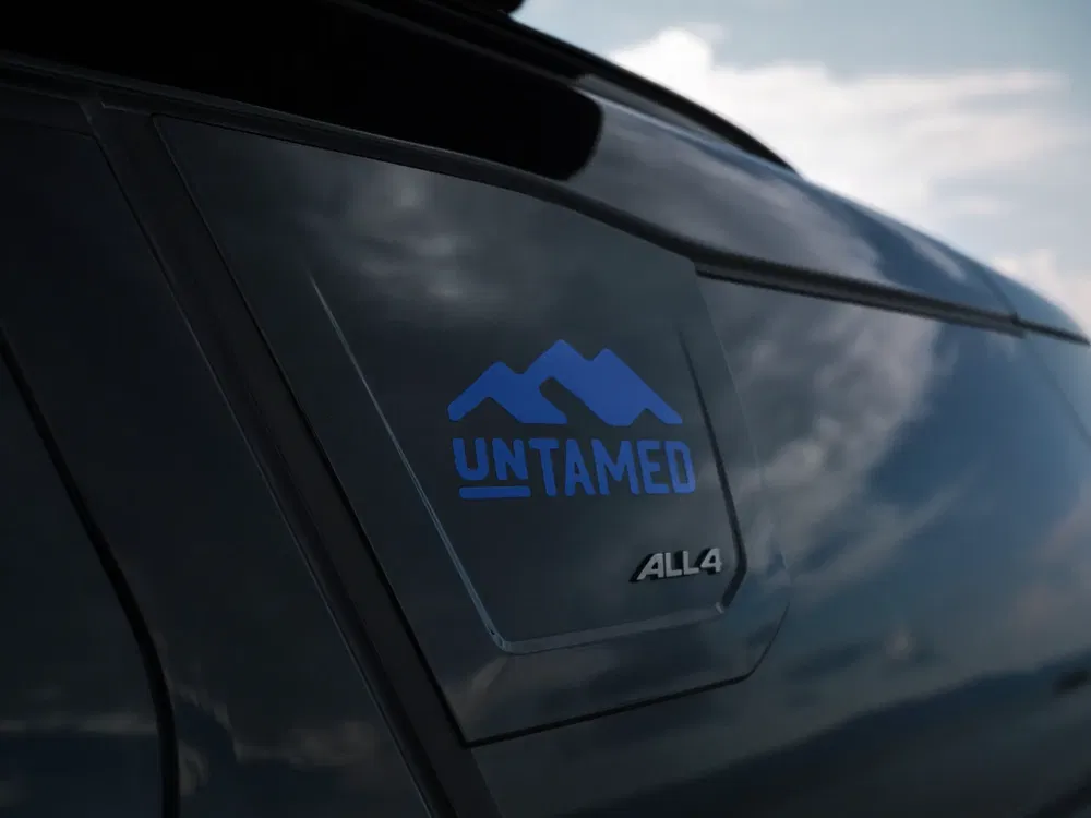 {"fr":"Détail arrière d'un véhicule Mini Untamed avec badge ALL4 et ciel en arrière-plan.","nl":"Achterdetail van een Mini Untamed voertuig met ALL4-badge en lucht op de achtergrond."}