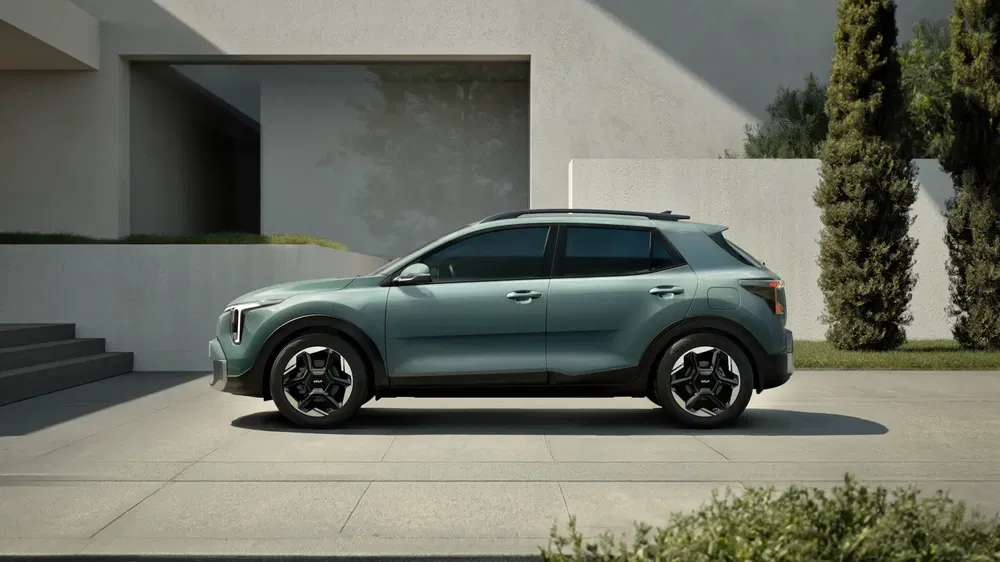 Groene Kia Niro SUV geparkeerd voor een modern huis, elegant en eigentijds ontwerp.