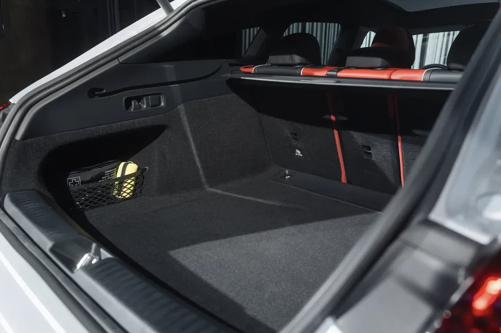 Coffre spacieux d'un SUV moderne avec rangement latéral, sièges arrière rabattus.