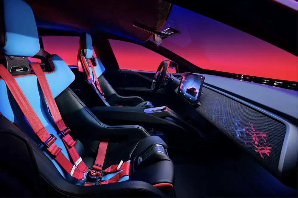 Intérieur futuriste de l'Alpine A290_β avec sièges sport bleus et harnais rouges.