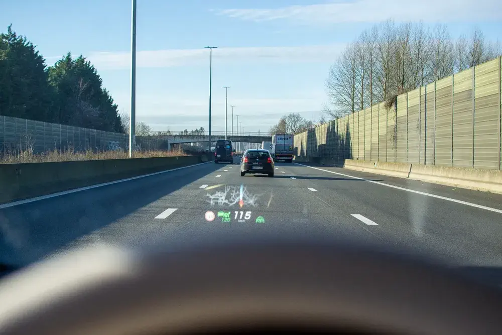 Affichage tête haute de vitesse sur autoroute claire avec voitures en file.