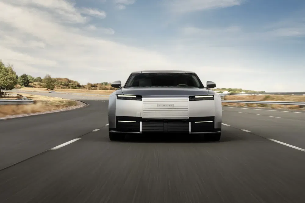 Moderne elektrische auto op weg, futuristisch hoekig ontwerp bij daglicht.