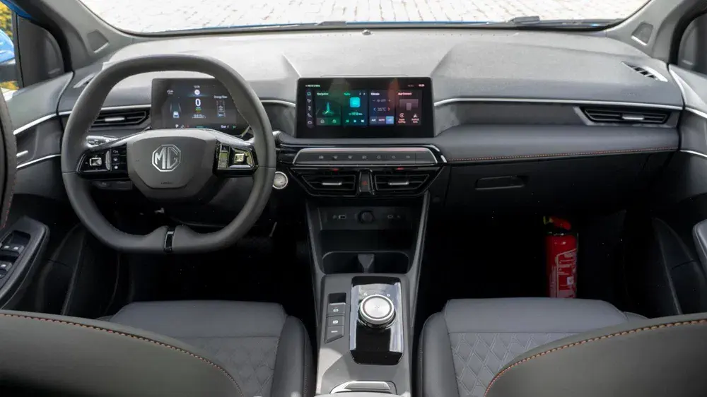 Moderne MG auto-interieur met stuur en centraal touchscreen.