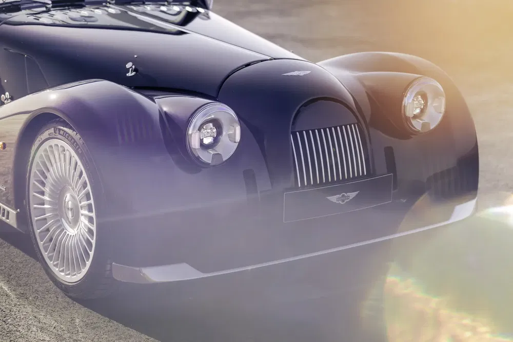 Voiture de sport Morgan Aero avec phares ronds et calandre distinctive en plein soleil.