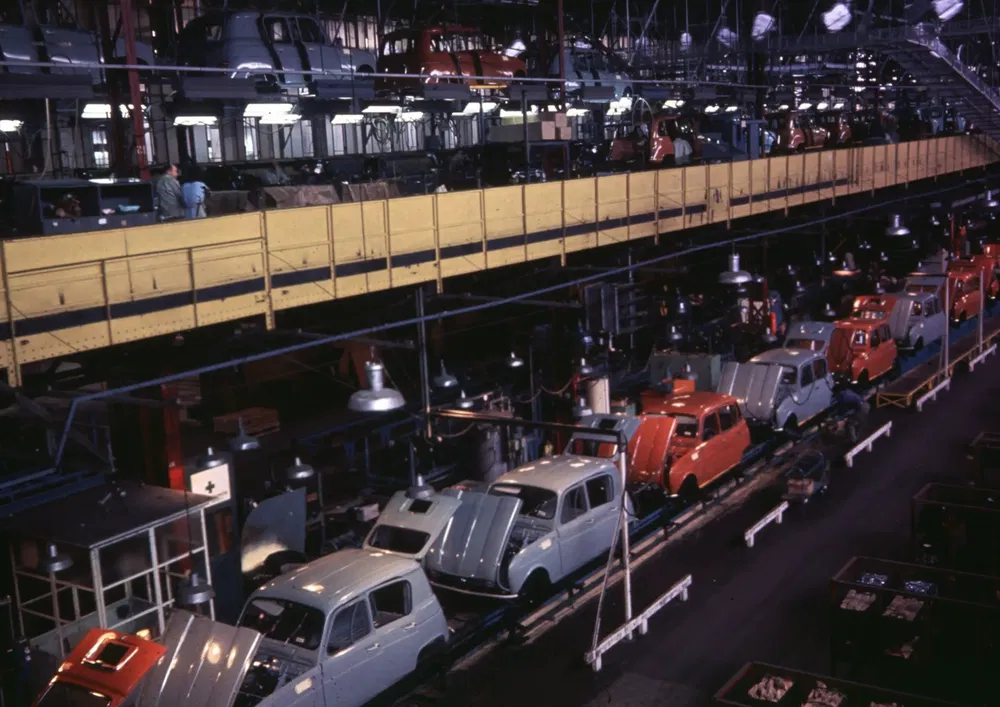 Renault 4 productielijn met kleurrijke carrosserieën op rij tijdens fabricageproces.