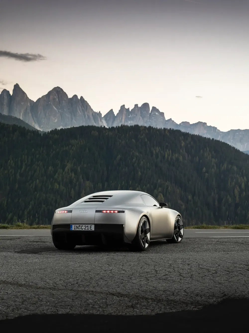 Concept-car Audi au design futuriste devant des montagnes majestueuses au crépuscule.