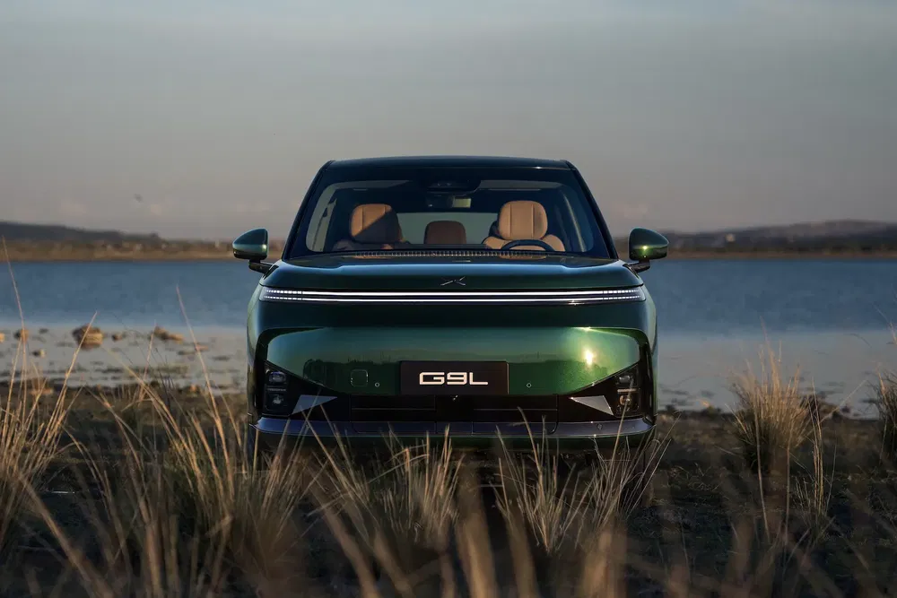 Vue avant du SUV électrique G9L vert au bord d'un lac pittoresque.