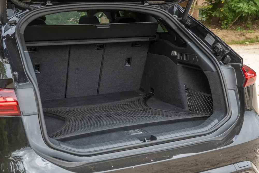 Coffre spacieux d'une voiture moderne avec tapis antidérapant et banquettes rabattables.