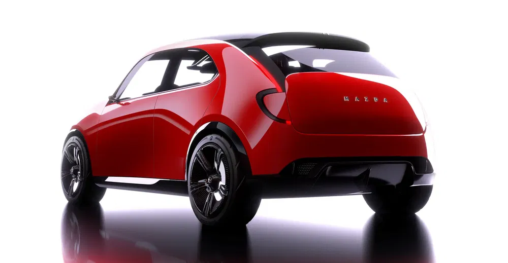 Rode Mazda conceptauto met futuristisch ontwerp en lichtmetalen velgen tegen een witte achtergrond.