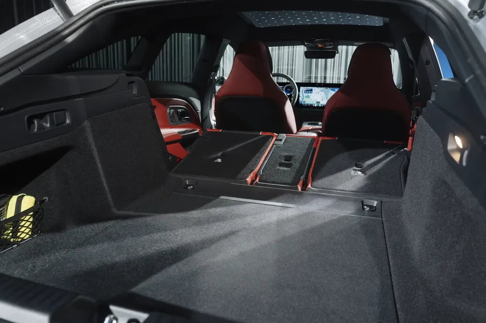 Intérieur spacieux de voiture avec sièges rabattus et tableau de bord high-tech moderne.