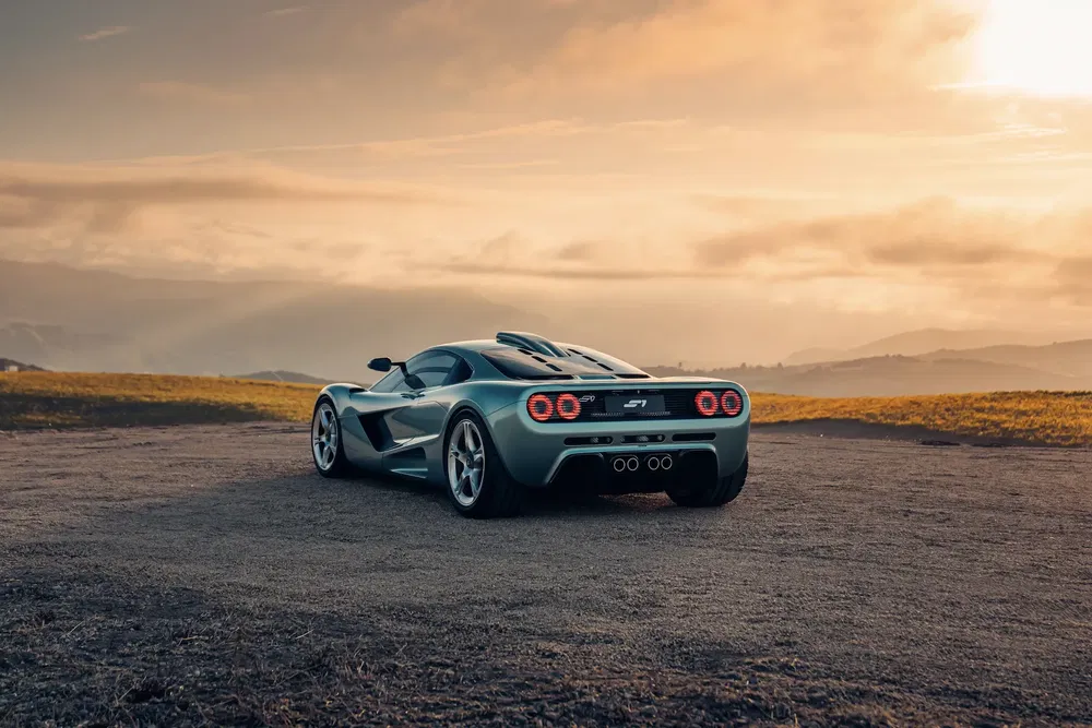 {"fr":"Supercar Gordon Murray T.50 sur route panoramique au coucher du soleil, arrière imposant.","nl":"Supercar Gordon Murray T.50 op panoramische weg bij zonsondergang, indrukwekkende achterkant."}