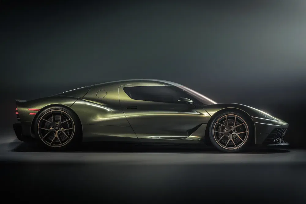 Voiture de sport verte luxueuse à profil bas et jantes métalliques élégantes.