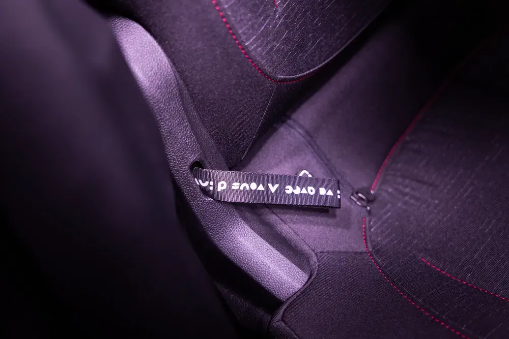 Intérieur de voiture haut de gamme avec étiquette de siège en tissu noir avec coutures rouges.