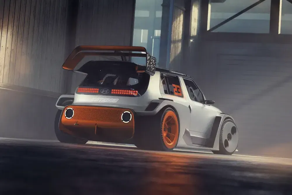 Hyundai conceptauto met futuristisch ontwerp en oranje velgen in een industriële garage.