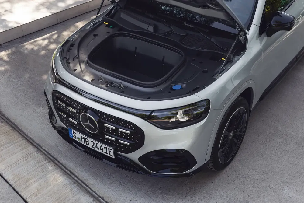 {"fr":"Mercedes-Benz électrique avec capot ouvert, montrant le compartiment avant vide.","nl":"Elektrische Mercedes-Benz met open motorkap, lege voorcompartiment."}