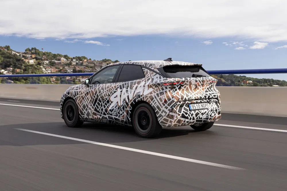 {"fr":"SUV avec camouflage complexe, roulant sur autoroute, ville en arrière-plan.","nl":"SUV met ingewikkeld camouflagepatroon, rijdt op snelweg, stad op de achtergrond."}