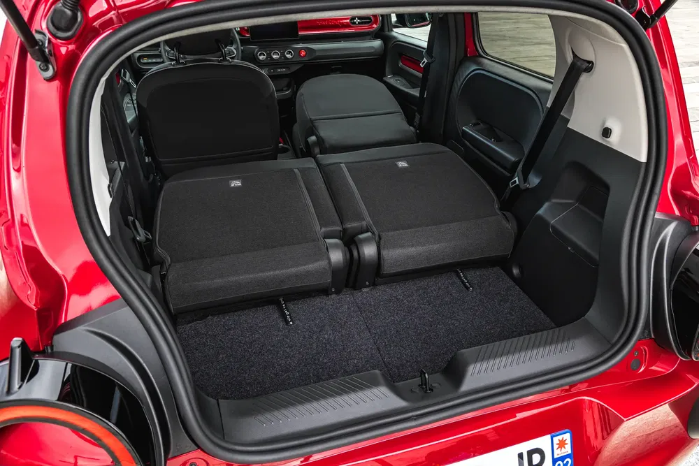 Vue intérieur d'une Fiat Panda rouge avec sièges rabattus, offrant un vaste espace de chargement.