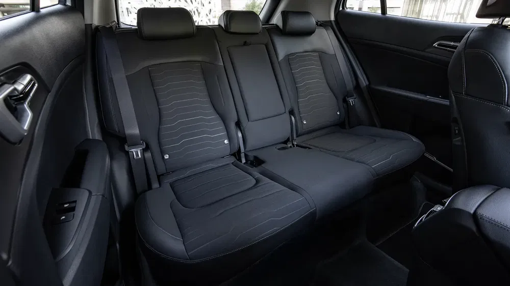 Intérieur spacieux de la Kia Cee'd avec sièges arrière en tissu noir moderne.