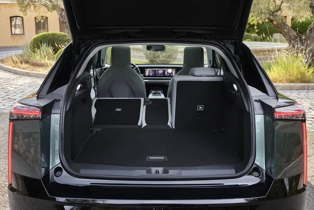 Ruime kofferbak van een moderne SUV met neergeklapte stoelen en digitaal interieur.