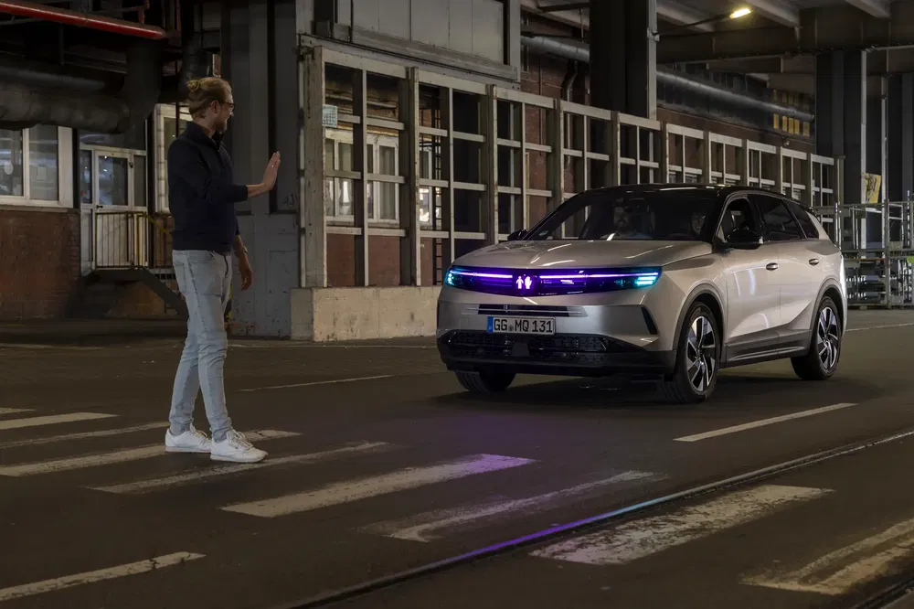 Moderne SUV Opel met LED-koplampen in een donkere industriële opslagplaats.