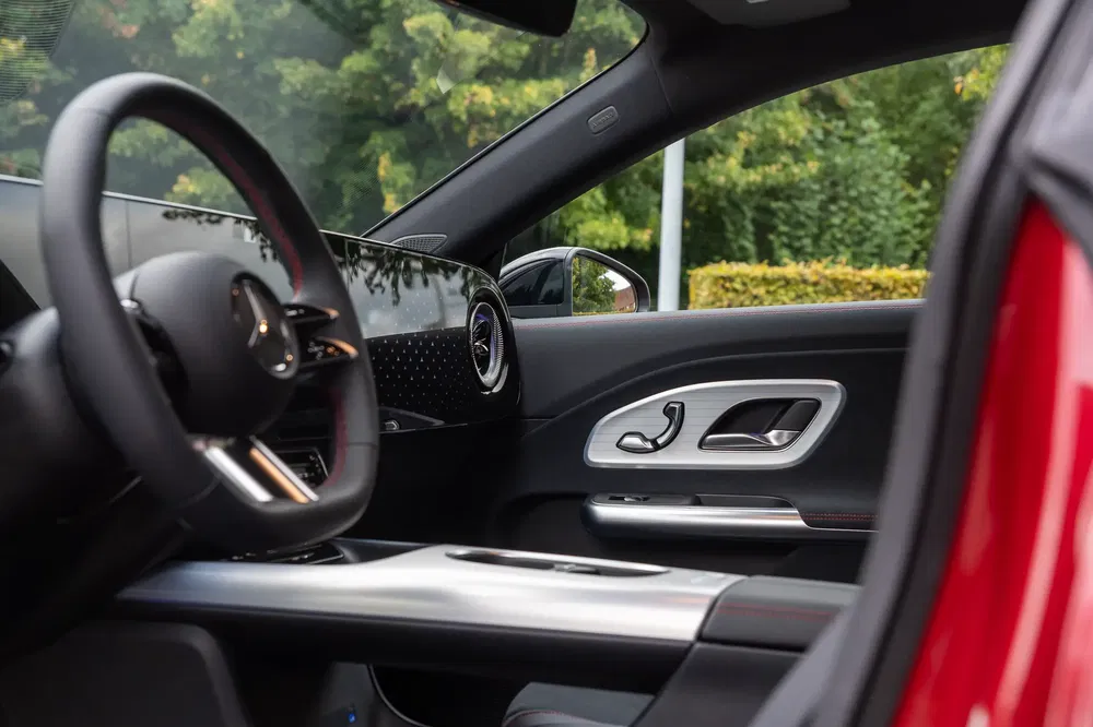 Luxe interieur van Mercedes met digitaal dashboard, zwart stuur en elegante afwerking.