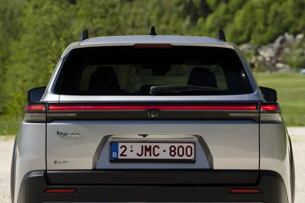 Vue arrière du SUV électrique Toyota bZ4X avec plaque d'immatriculation belge en nature.