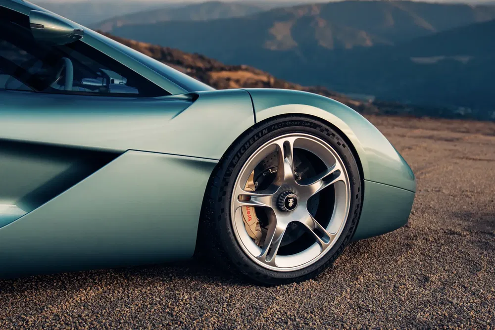 Gordon Murray T.33 vert sur route, gros plan sur roue avant et carrosserie élégante.