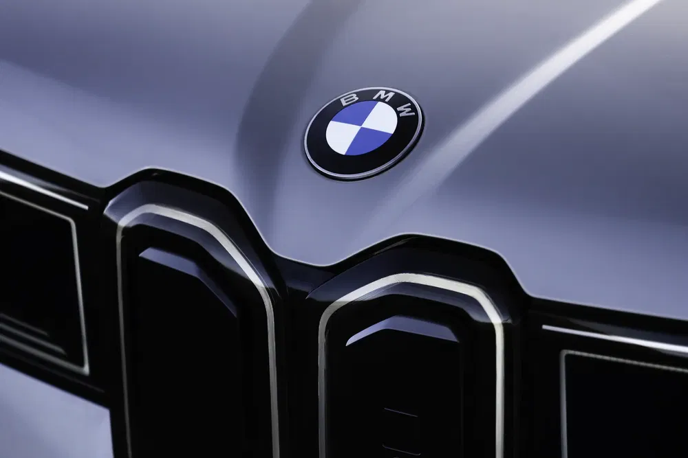 {"fr":"Logo BMW sur capot de voiture, détails brillants sur calandre moderne.","nl":"BMW-logo op autokap, glanzende details op moderne grille."}