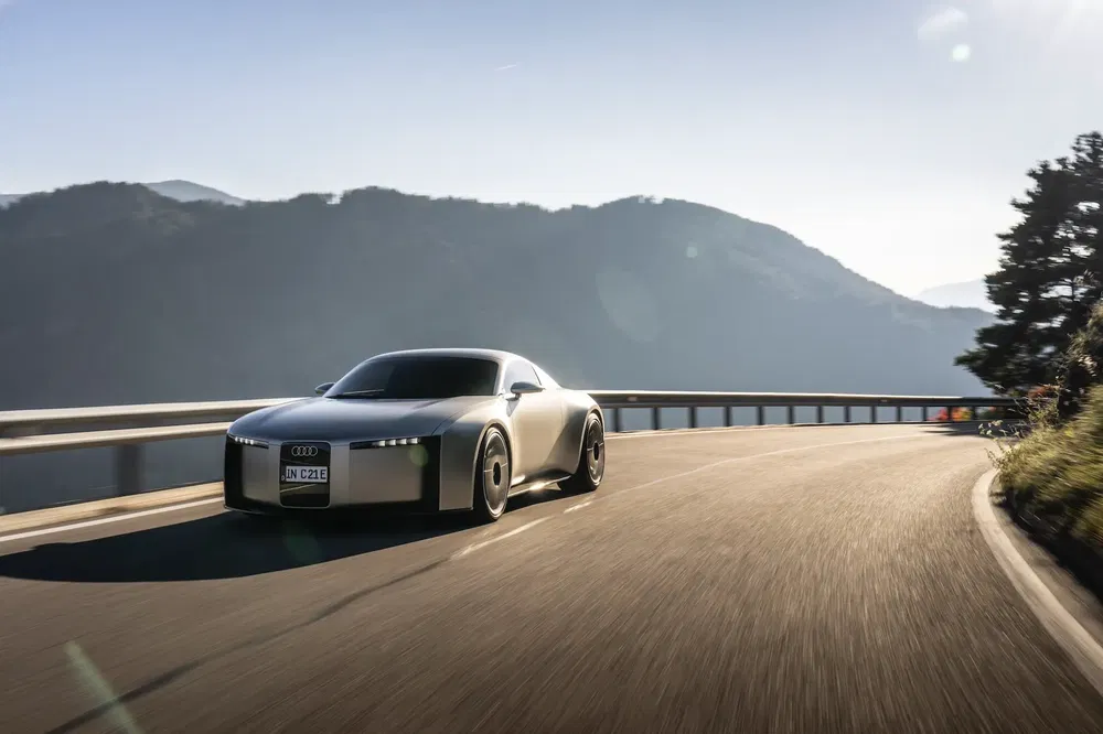 Concept car Audi sur route de montagne ensoleillée, design futuriste et dynamique.