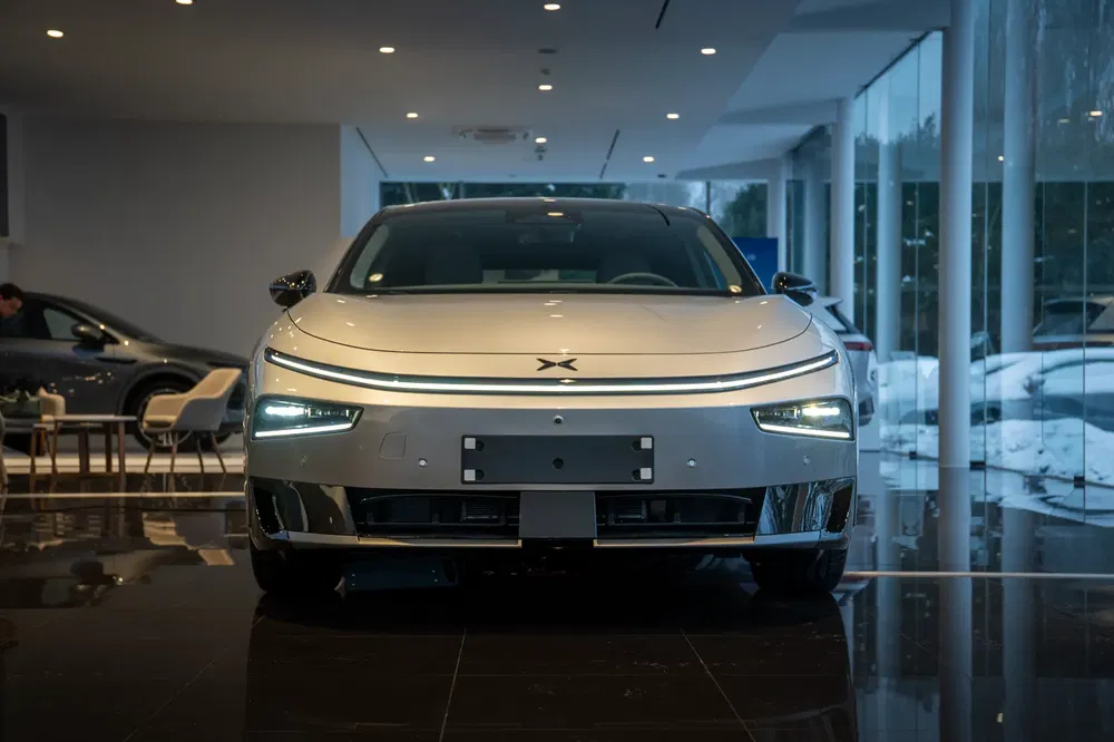 {"fr":"Voiture électrique Xpeng P7 argentée dans un showroom moderne et lumineux.","nl":"Zilveren Xpeng P7 elektrische auto in een moderne, verlichte showroom."}