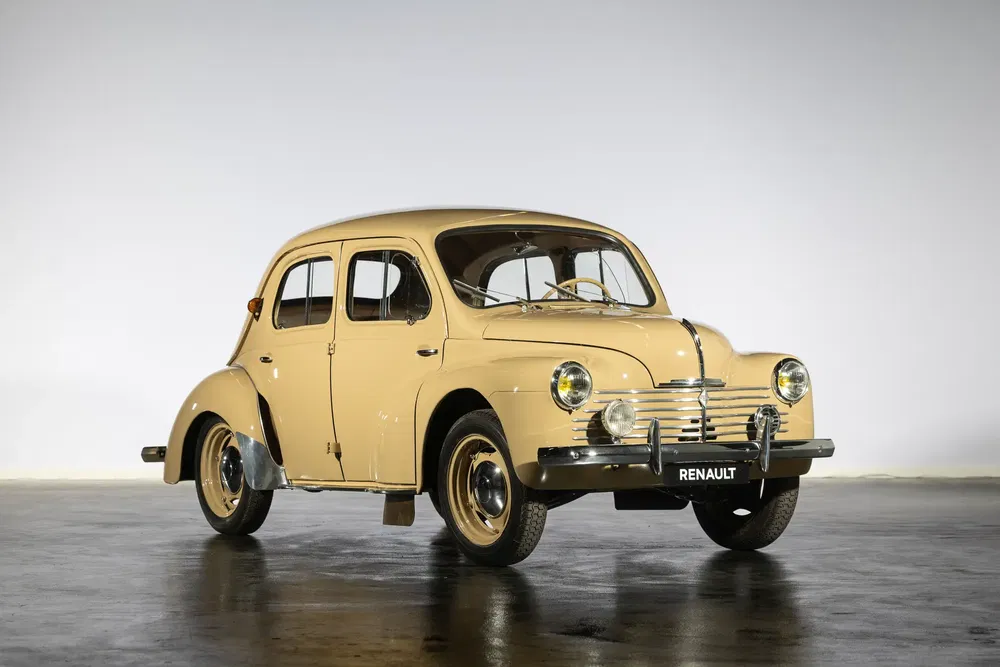 Renault classique beige 4CV sur fond neutre, design rétro, années 1940-1950.