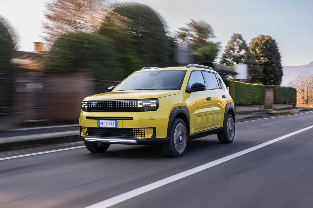 {"fr":"SUV Fiat jaune vibrant roulant rapidement sur une route urbaine, arbres en arrière-plan.","nl":"Felgele Fiat SUV rijdt snel op stedelijke weg, bomen op de achtergrond."}
