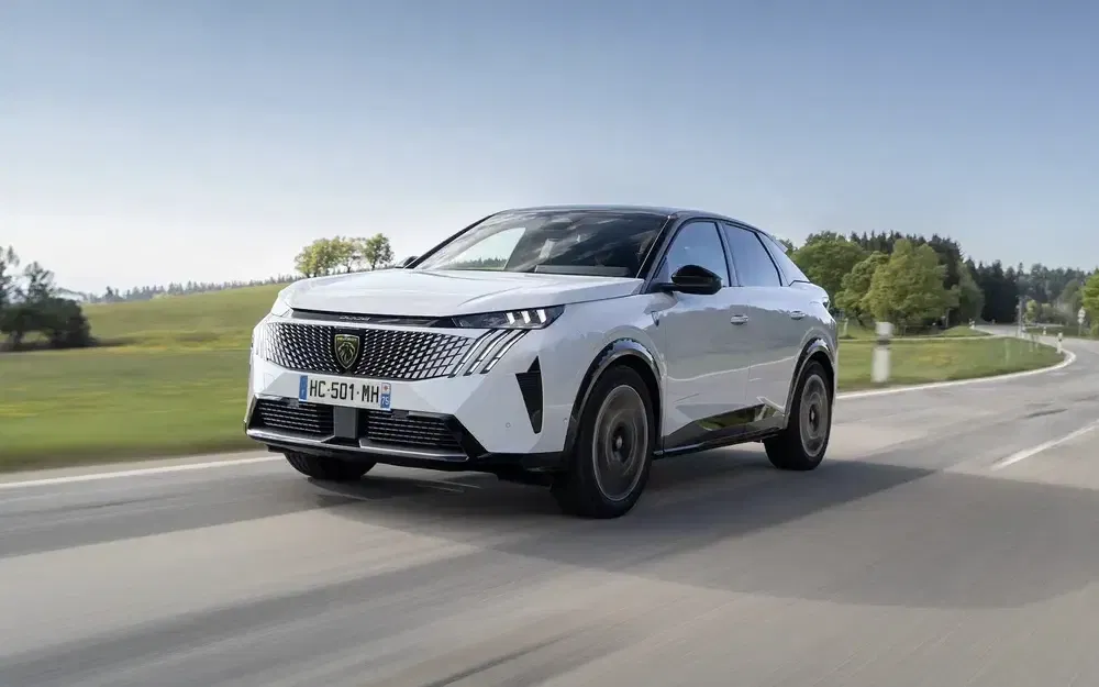 Peugeot 3008 2024 roulant sur une route de campagne en pleine journée.