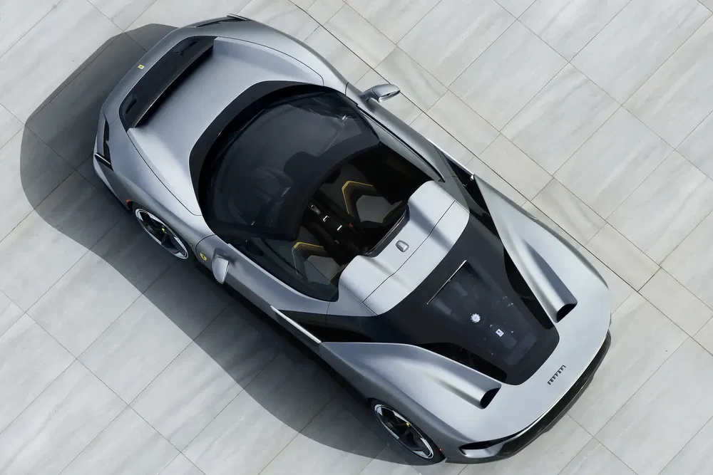 Ferrari SF90 Stradale argenté vue de dessus, design sportif et élégant sur fond clair.