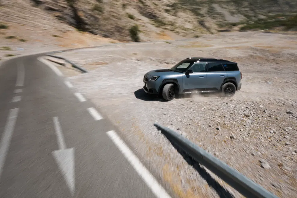 Mercedes-Benz GLB roulant sur route sinueuse en terrain sec et rocailleux.