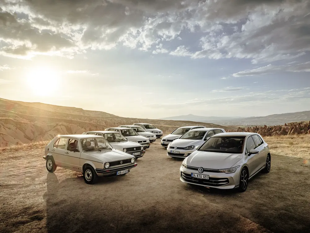 Collection de voitures Volkswagen Golf sous le soleil couchant dans un paysage désertique.