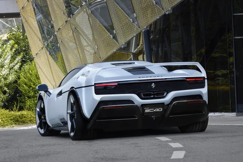 Ferrari SC40 blanche stationnée devant un bâtiment moderne, style sport luxueux.