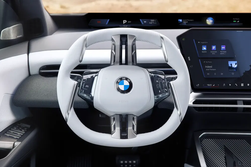 Luxe interieur van een BMW iX met modern stuur en stijlvol digitaal scherm.