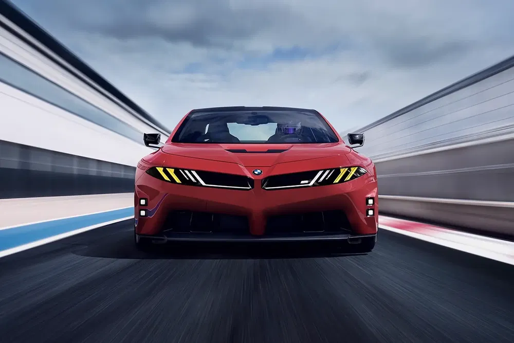 Voiture de sport rouge rapide sur piste, gros plan de l'avant montrant les phares angulaires.