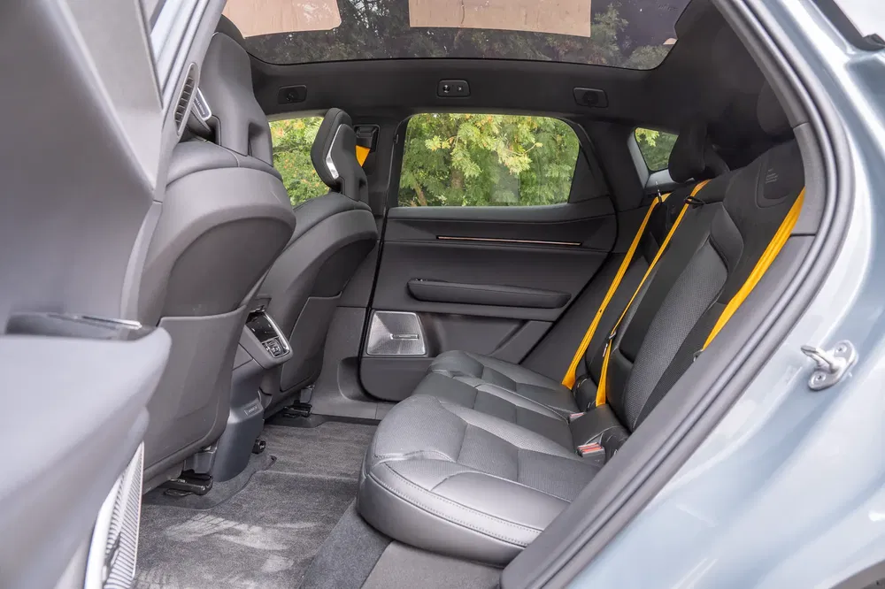 Intérieur d'une berline Polestar avec sièges en cuir noir et ceintures de sécurité jaunes.