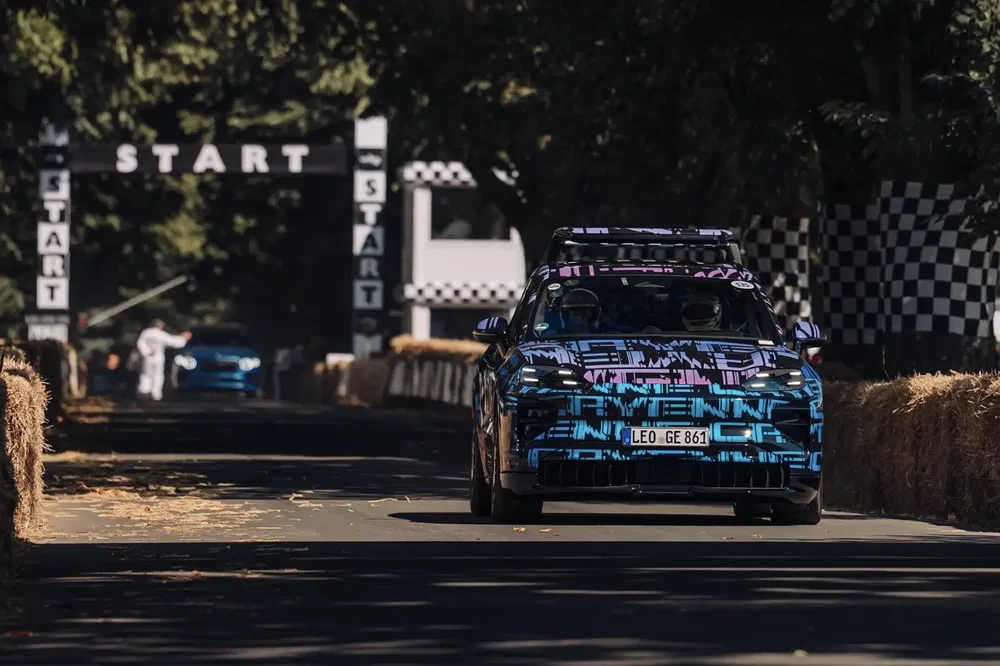 Voiture Porsche camouflée sur piste de démarrage avec architecture de style racing.