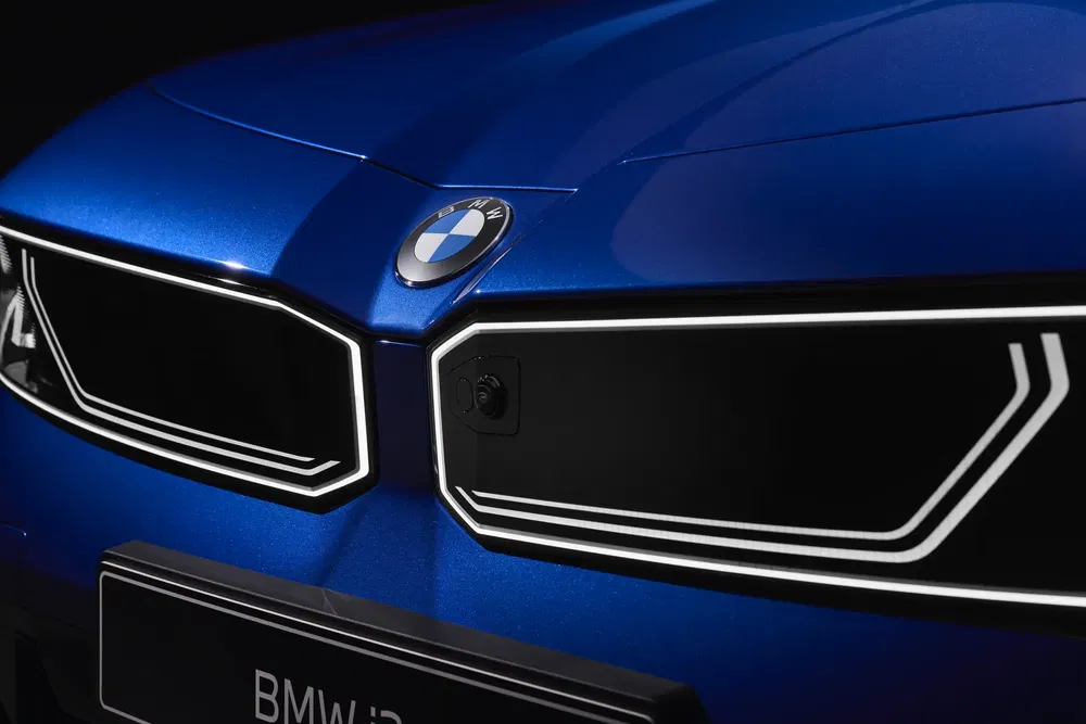 Nabijzicht van de elektrische BMW grille met logo op blauwe achtergrond.
