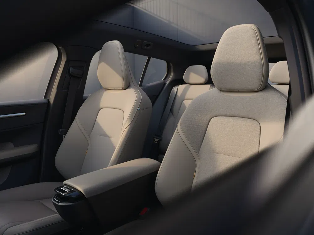 Intérieur de voiture moderne avec sièges avant en cuir beige et accoudoirs centraux.