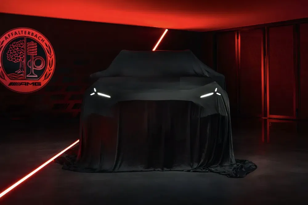 AMG-auto onder doek met brandende LED-koplampen, rode achtergrond affalterbach.