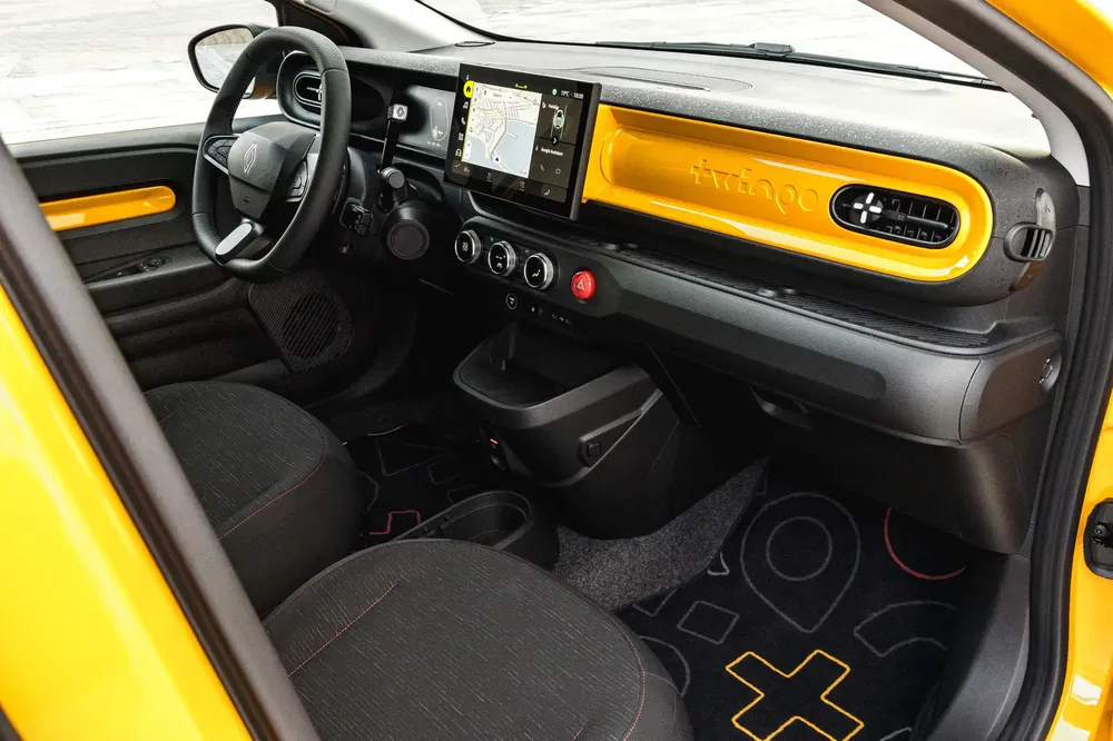 Renault Twingo geel interieur met centraal navigatiescherm en moderne afwerking.